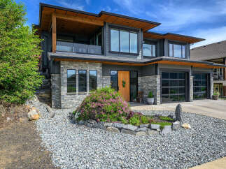 This stunning modern home boasts a beautiful exterior with a combination of stone and wood accents.