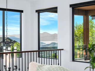 Experience breathtaking views from this stunning property, featuring expansive windows that frame the majestic mountains and serene lake.