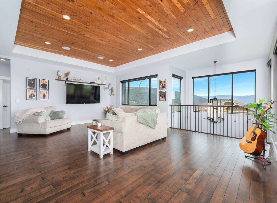 This stunning property boasts a spacious living area with a beautiful wooden ceiling and hardwood floors, creating a warm and inviting atmosphere.