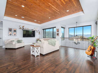 This stunning property boasts a spacious living area with a beautiful wooden ceiling and hardwood floors, creating a warm and inviting atmosphere.