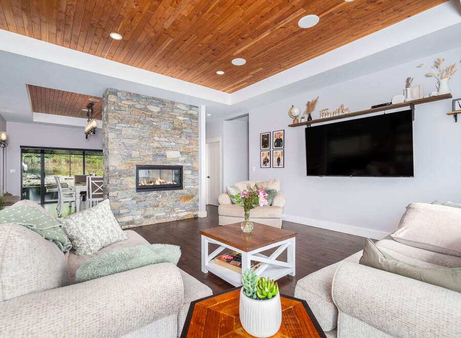 Step into luxury with this stunning living room, featuring a cozy fireplace and a modern entertainment setup.