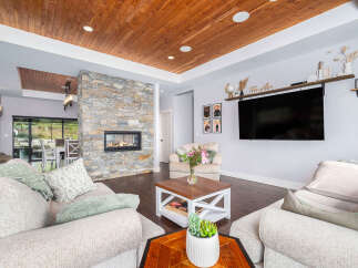 Step into luxury with this stunning living room, featuring a cozy fireplace and a modern entertainment setup.