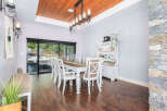 Step into this elegant dining room, featuring a stunning wood ceiling and a stylish chandelier.