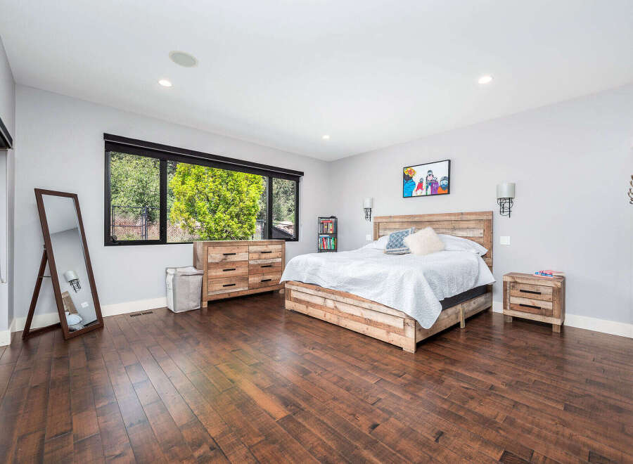 Step into this stunning bedroom featuring a rustic wooden bed frame and matching nightstand.