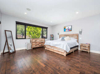 Step into this stunning bedroom featuring a rustic wooden bed frame and matching nightstand.
