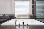 Indulge in luxury with this stunning bathroom featuring a modern soaking tub.