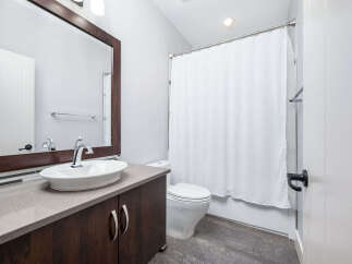 This modern bathroom features a sleek vanity with a stylish vessel sink and a large mirror.