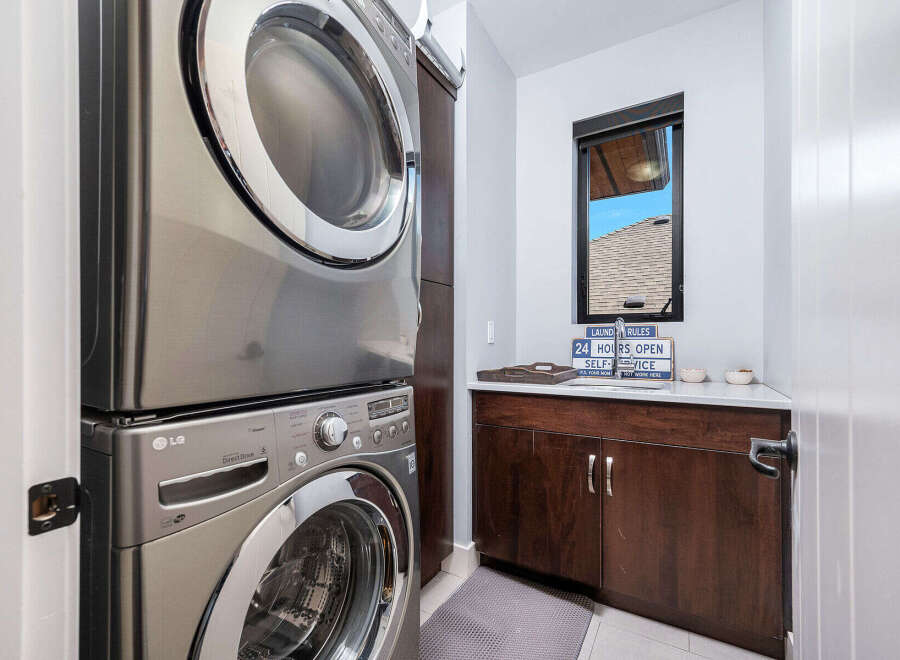 This modern laundry room features a sleek, stacked LG washer and dryer, maximizing space and efficiency.