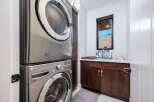 This modern laundry room features a sleek, stacked LG washer and dryer, maximizing space and efficiency.