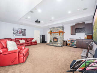 Step into luxury with this stunning living space, featuring a cozy fireplace and a stylish wet bar, perfect for entertaining.