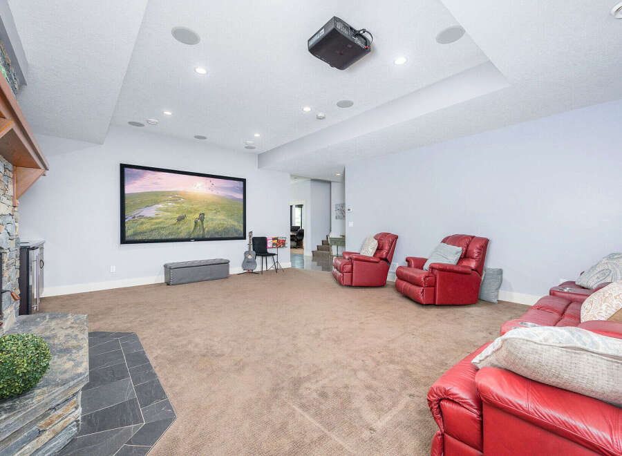 Step into luxury with this stunning home theater! Featuring a large screen, comfortable seating, and a cozy fireplace, this space is perfect for movie nights or entertaining guests.