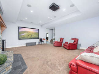 Step into luxury with this stunning home theater! Featuring a large screen, comfortable seating, and a cozy fireplace, this space is perfect for movie nights or entertaining guests.