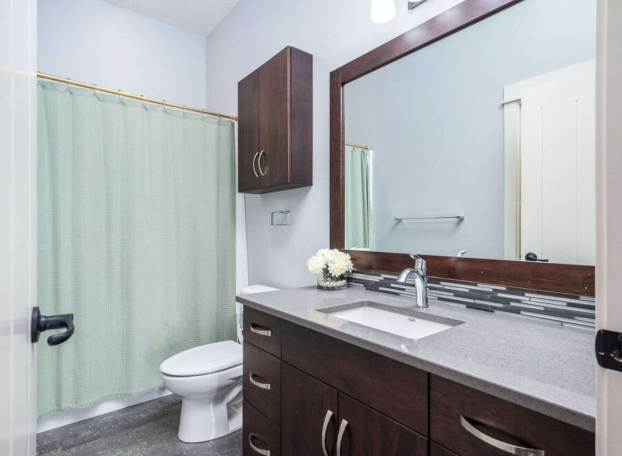 This stunning bathroom boasts a modern design with a sleek vanity and a spacious countertop.