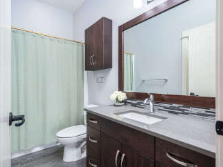 This stunning bathroom boasts a modern design with a sleek vanity and a spacious countertop.
