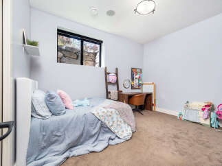 This charming bedroom offers a cozy retreat with its soft color palette and inviting ambiance.