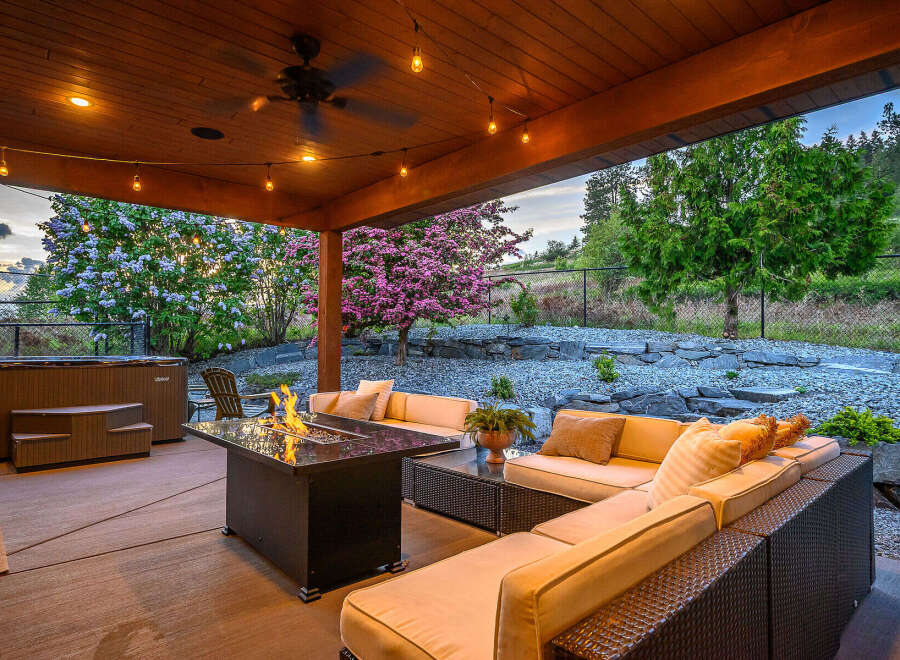 Experience luxury living in this stunning outdoor oasis! This property boasts a cozy seating area with a fire pit, perfect for entertaining or relaxing.