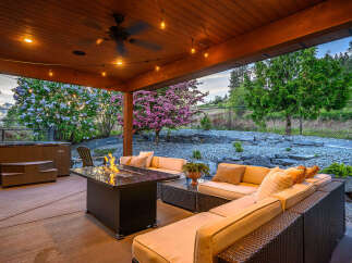 Experience luxury living in this stunning outdoor oasis! This property boasts a cozy seating area with a fire pit, perfect for entertaining or relaxing.