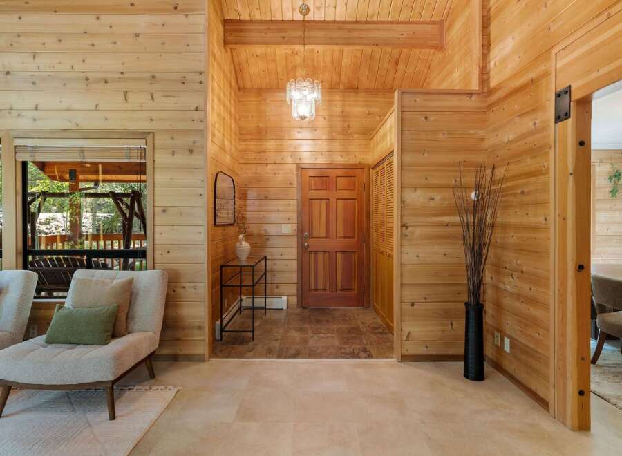 Step into this stunning home featuring warm wood paneling and a welcoming entryway.