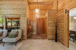 Step into this stunning home featuring warm wood paneling and a welcoming entryway.