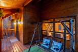 Step into rustic charm with this inviting porch, perfect for relaxing and enjoying the surrounding natural beauty.