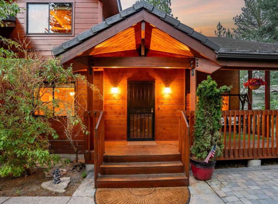 Welcome to your dream home! This stunning property boasts a charming wooden exterior and a welcoming front porch, perfect for enjoying the serene surroundings.