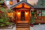 Welcome to your dream home! This stunning property boasts a charming wooden exterior and a welcoming front porch, perfect for enjoying the serene surroundings.