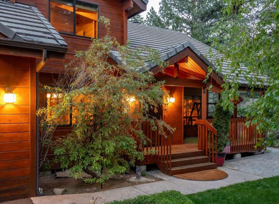 This stunning property boasts a warm and inviting exterior with beautiful wood siding and a charming front porch.