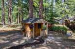 Nestled in a serene wooded setting, this charming wooden playhouse offers a delightful escape for children.