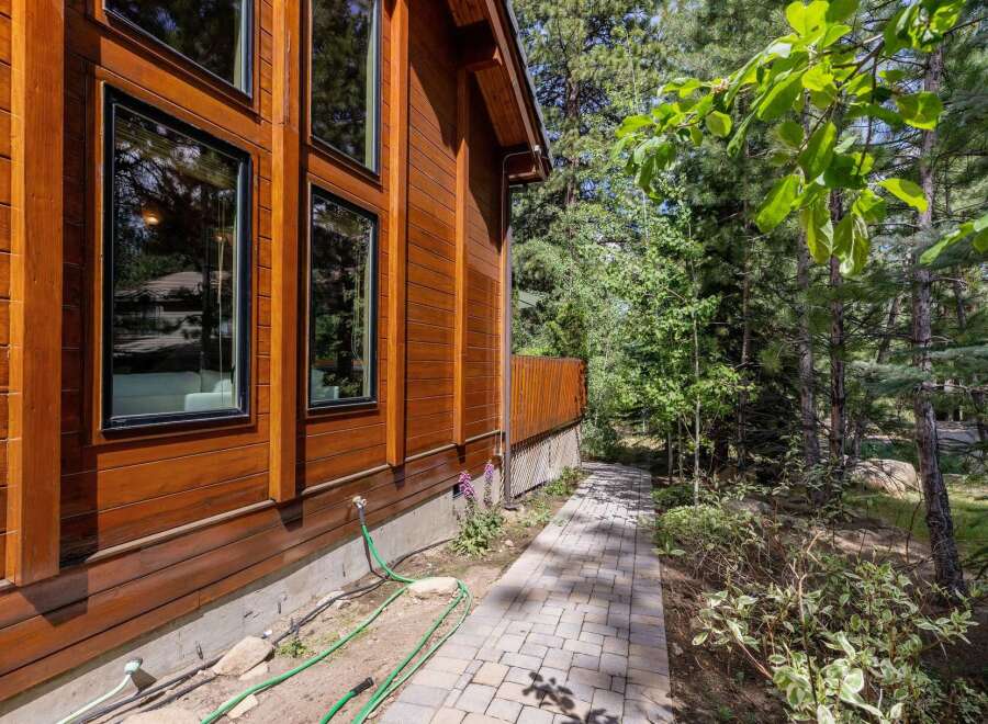 This stunning property boasts a beautiful wooden exterior, complemented by large windows that offer ample natural light.