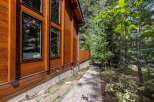 This stunning property boasts a beautiful wooden exterior, complemented by large windows that offer ample natural light.