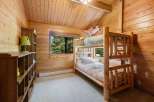 This charming bedroom features a rustic bunk bed, perfect for a cozy and inviting space.