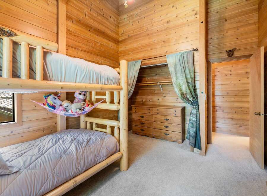 This cozy bedroom features a unique log-style bunk bed, perfect for a children's room or a vacation home.