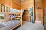 This cozy bedroom features a unique log-style bunk bed, perfect for a children's room or a vacation home.