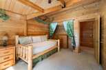 Step into a cozy retreat with this charming bedroom, featuring rustic wood paneling and a comfortable bed.