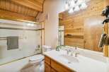 Step into this charming bathroom featuring a rustic wood accent wall and a bright, clean vanity.