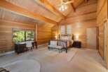 Step into a rustic retreat with this stunning bedroom featuring warm wood paneling and a vaulted ceiling.