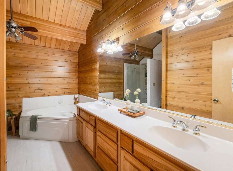 Step into a luxurious bathroom retreat featuring stunning wood paneling and a spacious layout.