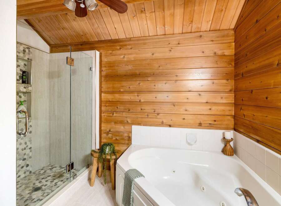 This stunning bathroom boasts a luxurious soaking tub and a separate glass-enclosed shower, perfect for unwinding after a long day.
