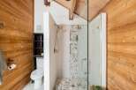 Step into a beautifully designed bathroom featuring natural wood accents and a modern glass shower.