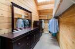 Step into luxury with this stunning walk-in closet, featuring rich wood paneling and ample storage.