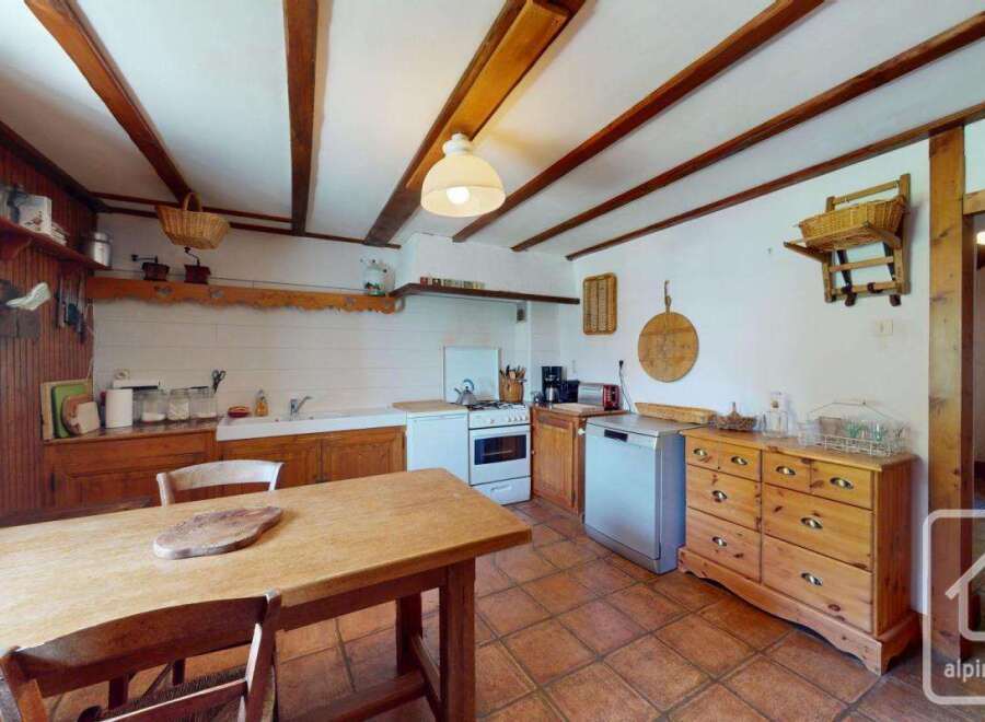 This charming kitchen boasts a rustic design with wooden beams and cabinetry, creating a warm and inviting atmosphere.