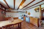 This charming kitchen boasts a rustic design with wooden beams and cabinetry, creating a warm and inviting atmosphere.