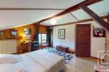 Discover the charm of this unique property, featuring a cozy bedroom with exposed wooden beams and a warm, inviting atmosphere.