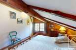 Discover the charm of this cozy bedroom, featuring exposed wooden beams and a warm, inviting atmosphere.
