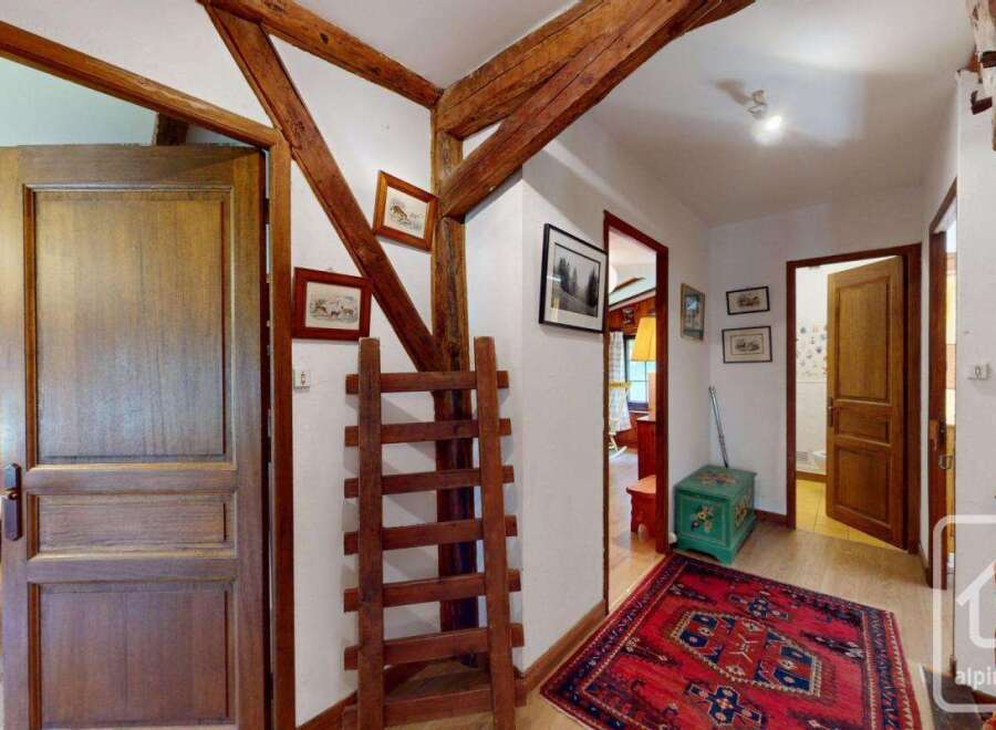 Step into a charming property with rustic wooden beams and a welcoming hallway.