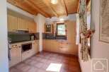 This charming kitchen boasts a warm and inviting atmosphere with its wooden ceiling and cabinetry.
