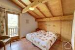 This charming bedroom boasts a cozy atmosphere with its wooden ceiling and walls, creating a warm and inviting space.