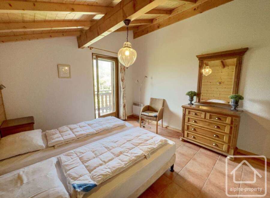 This charming bedroom features a cozy atmosphere with wooden beams and a warm color palette.