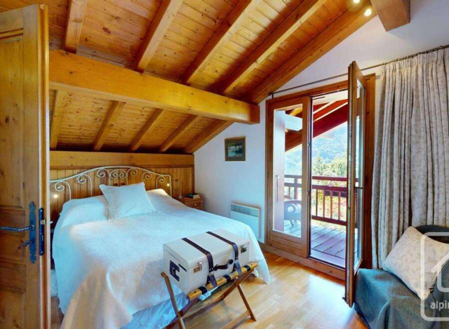 Discover the charm of this cozy bedroom, featuring a rustic wooden ceiling and a comfortable bed.