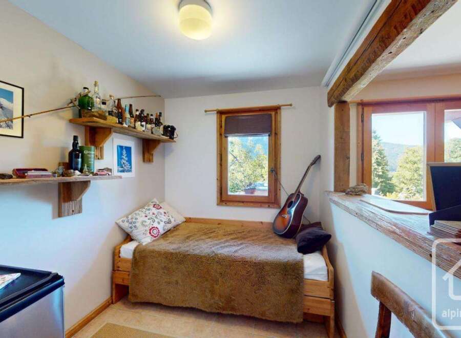 This cozy bedroom features a rustic wooden bed frame and a warm, inviting atmosphere.